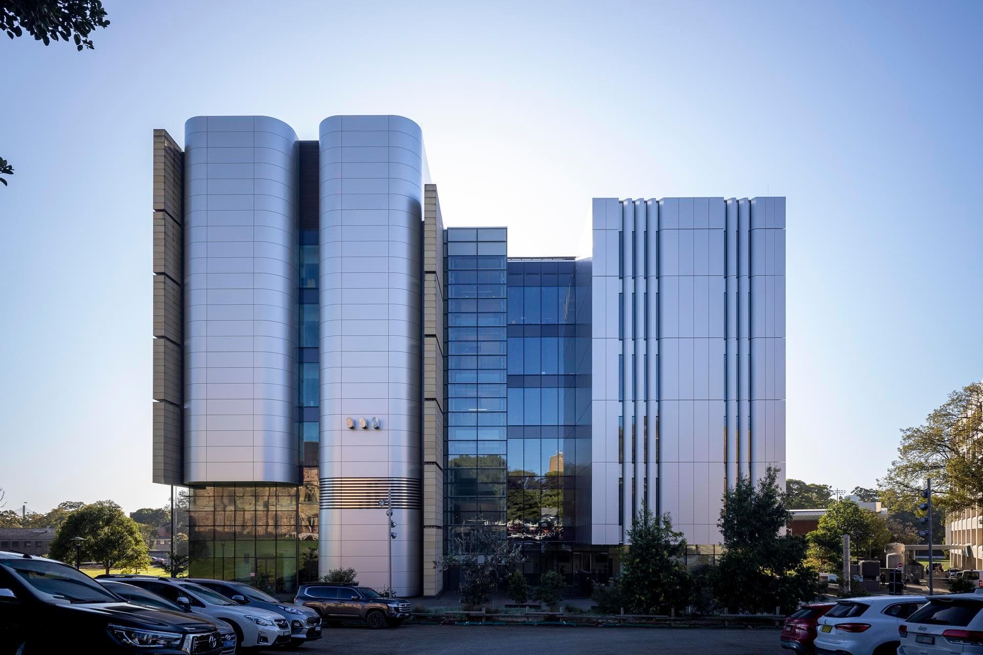 Modern façade of the Charles Perkins Centre highlighting Alpolic NC silver cladding panels with vertical strip windows.