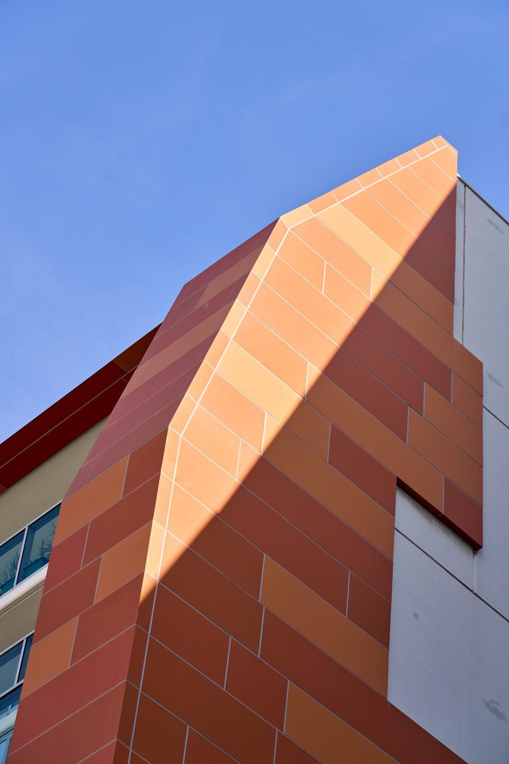 Close-up of Trilogi Apartments façade with ALPOLIC™ NC/A1 panels in Burnt Orange and Golden Orange