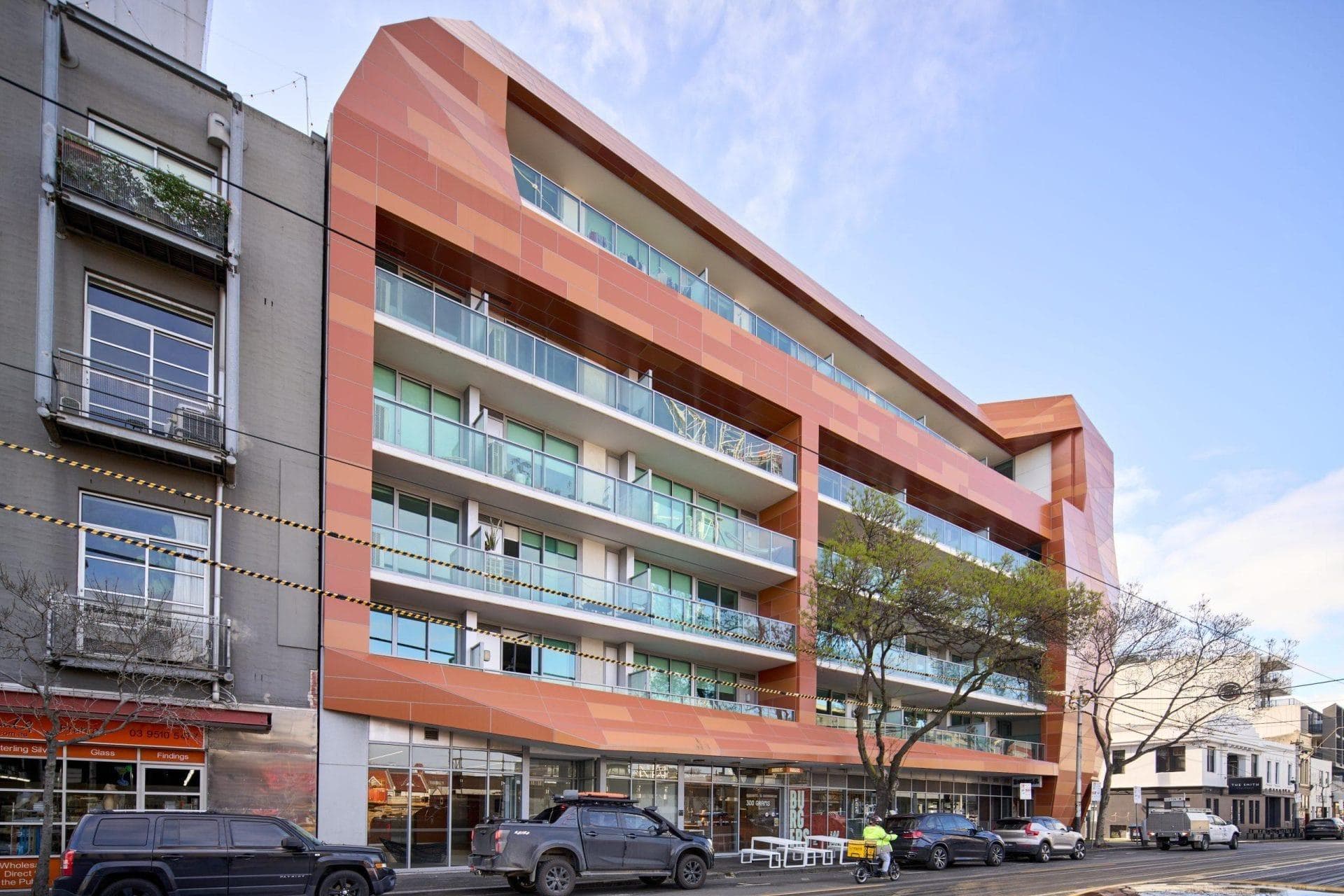 Street view of Trilogi Apartments with ALPOLIC™ NC/A1 façade in Burnt Orange and Tuscan Orange