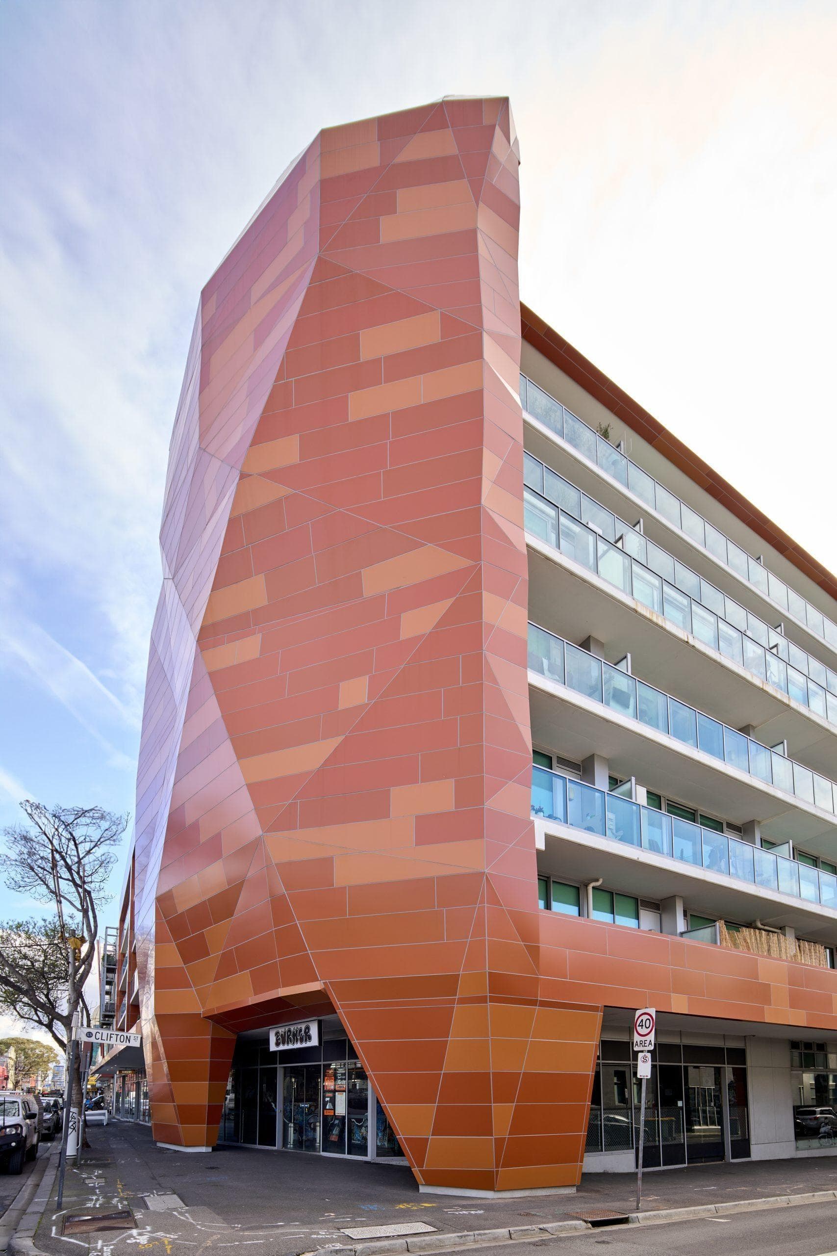 Architectural detail of Trilogi Apartments corner with ALPOLIC™ NC/A1 metallic orange panels